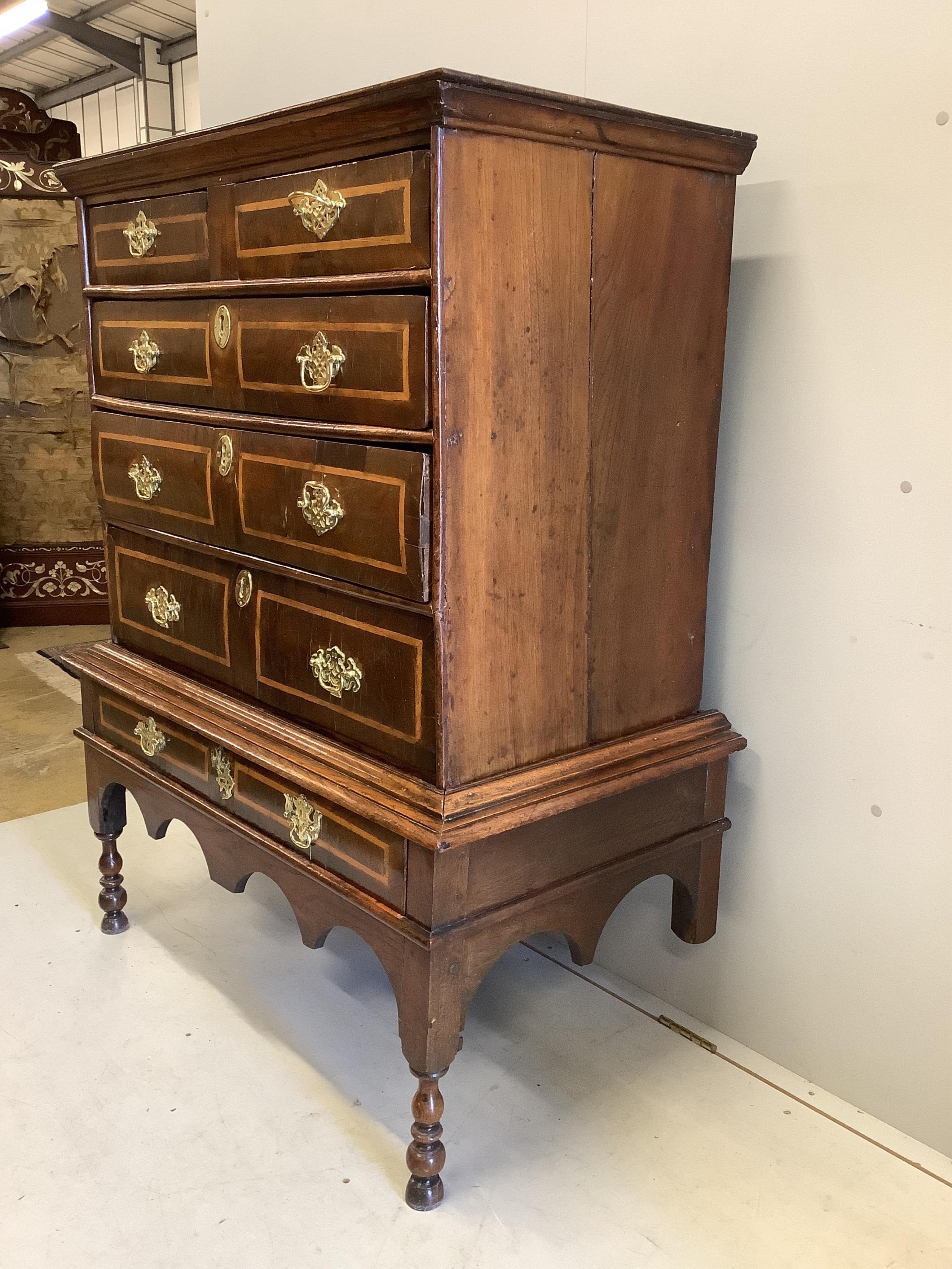 An early Georgian elm, oak and sycamore banded chest on stand, width 98cm, depth 53cm, height 135cm